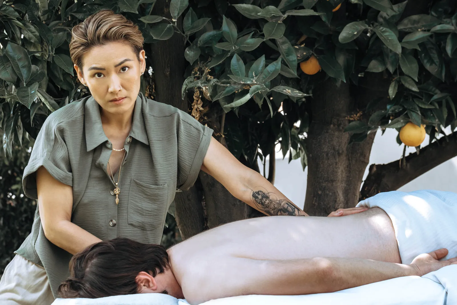 Angie Wong giving a hands-on myofascial release massage in the studio garden